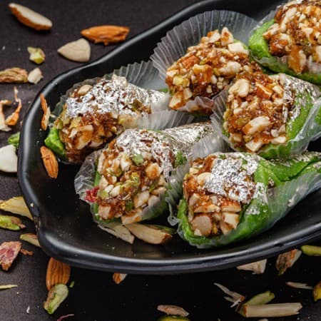 A paan filled with nuts and dripping with honey.